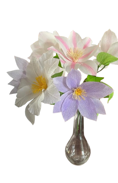Clematisbloemen van crêpepapier in wit, roze en lila in een glazen vaas