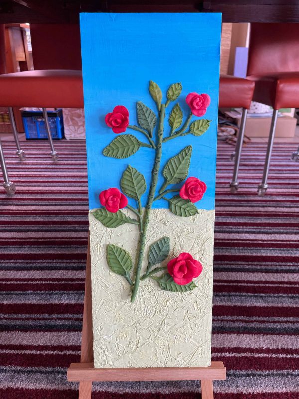 3D-kunstwerk van een rozentak met rode rozen op een blauw en crème paneel