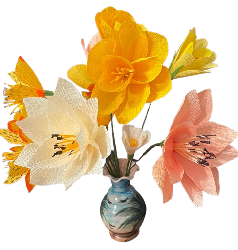 Boeketje van crêpepapier met gele, roze en witte bloemen in een blauwe vaas