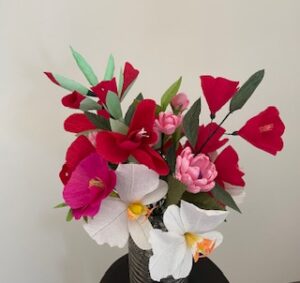 Bloemstuk van crêpepapier met bloemen in warme kleuren